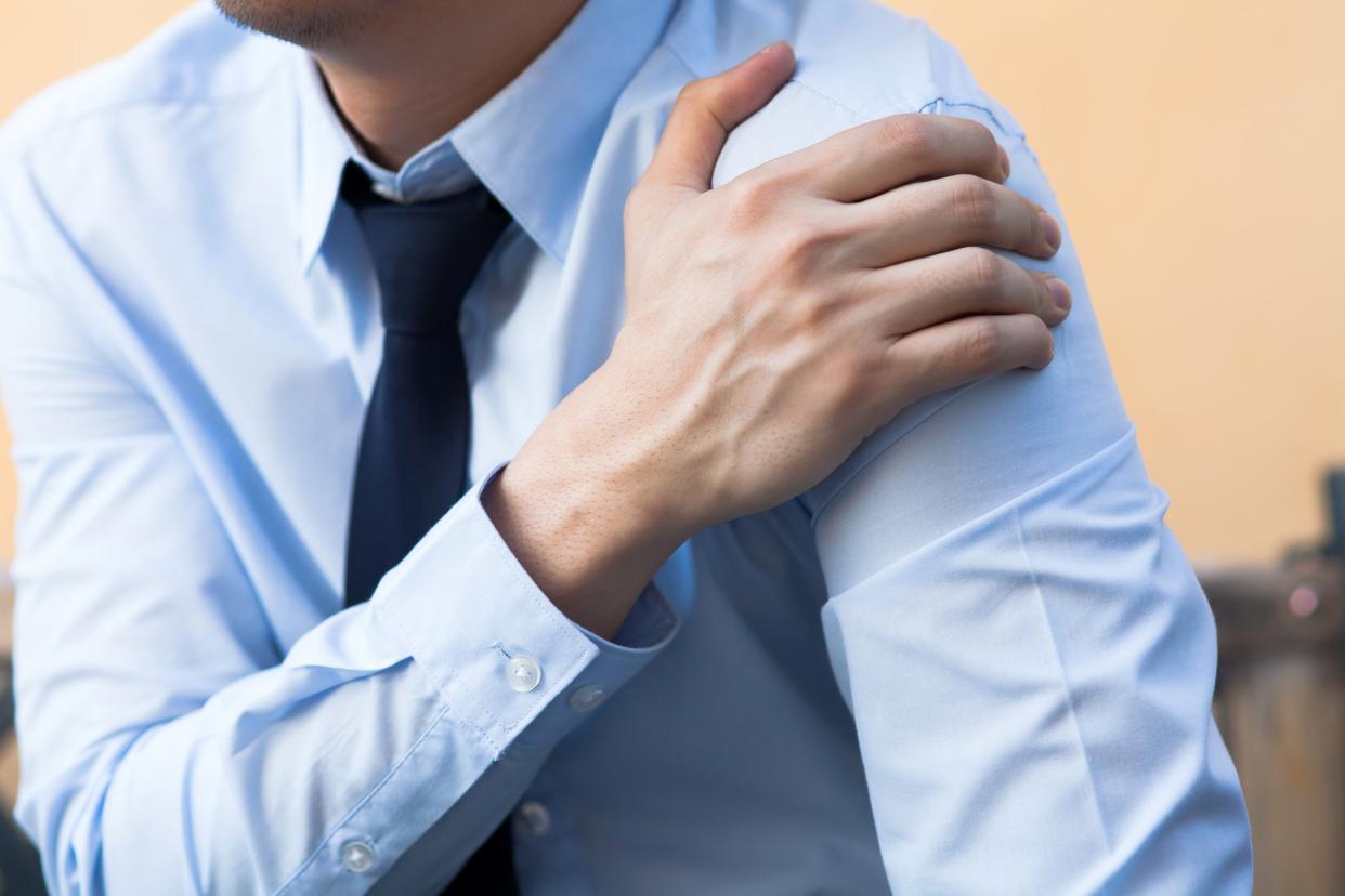 Businessman holding his arm in pain