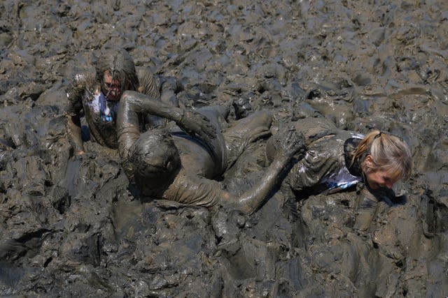 Competitors take part in the annual Maldon Mud Race, a charity event to race across the bed of the River Blackwater in Maldon, Essex 