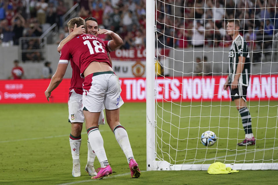 Wrexham forward Sam Dalby, left, celebrates his goal with teammate forward Billy Waters during the second half of a club friendly soccer match against Manchester United, Tuesday, July 25, 2023, in San Diego. (AP Photo/Gregory Bull)