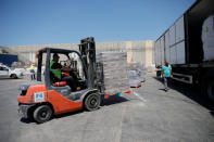 Workers arrange packages of goods ahead of their transfer to the Gaza Strip, inside the Kerem Shalom border crossing terminal between Israel and Gaza Strip, Israel August 15, 2018. REUTERS/Amir Cohen