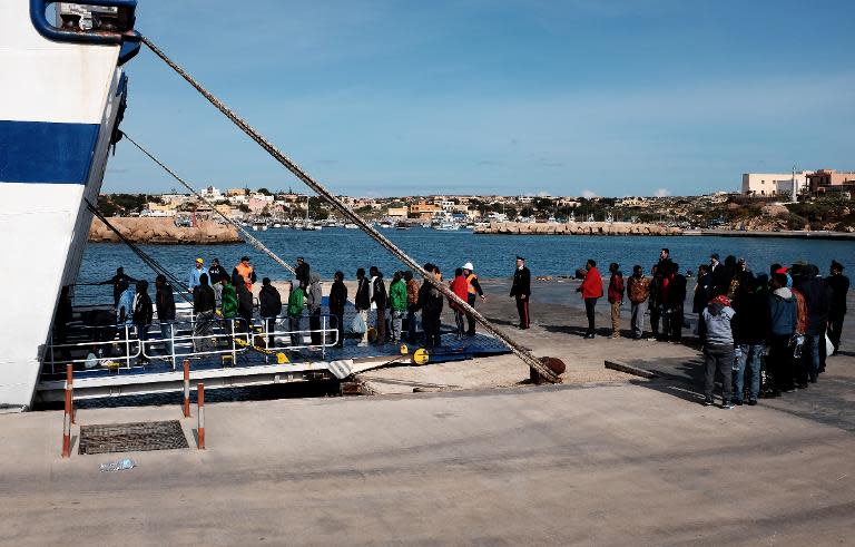 Migrants wait at the port of Lampedusa, Italy, to board a ferry bound for Porto Empedocle in Sicily on February 20, 2015