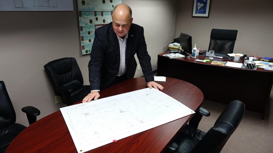 North Dundas Mayor Tony Fraser surveys a map of local roads, about one third of which are tar and chip.