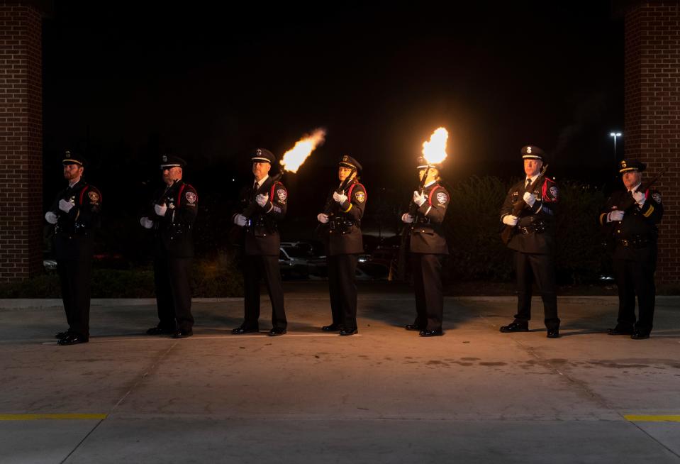 The Evansville Police Department honor guard fires a 21-gun salute during the funeral service of fallen Vanderburgh County Sheriff's Deputy Asson Anthony Hacker at Christian Fellowship Church in Evansville, Ind., Thursday evening, March 9, 2023.  