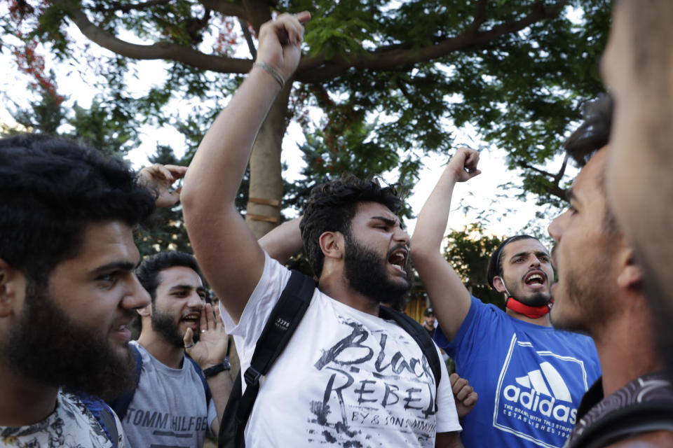 Anti-government protesters shout slogans in Beirut, Lebanon, Saturday, June 13, 2020. Lebanese protesters took to the streets in Beirut and other cities in mostly peaceful gatherings against the government, calling for its resignation as the small country sinks deeper into economic distress. (AP Photo/Hassan Ammar)