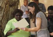 Britain's Kate, the Duchess of Cambridge, presents a certificate of achievement to local aboriginal woman at the National Indigenous Training Academy at Yulara, near Uluru, Australia, Tuesday, April 22, 2014. (AP Photo/Rob Griffith)