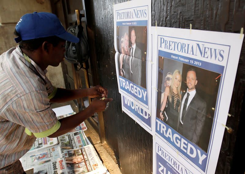 FILE PHOTO: Newspaper vendor sets up his stall outside court ahead of South African "Blade Runner" Oscar Pistorius' court appearance in Pretoria