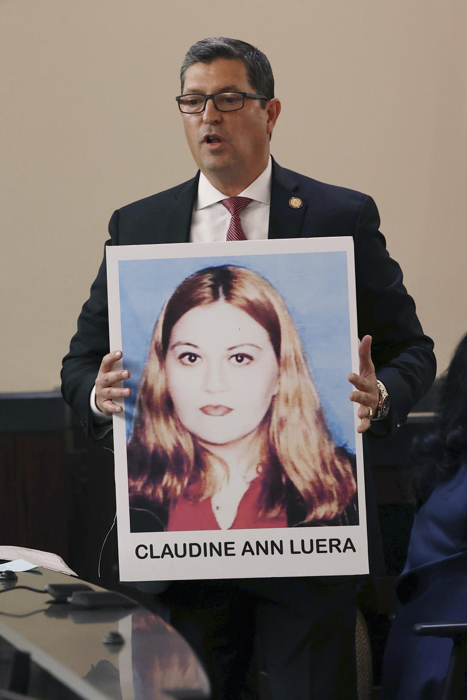 During opening statements, Webb County District Attorney Isidro R. "Chilo" Alaniz shows photographs of a victim during the capital murder trial of former U.S. Border Patrol supervisor Juan David Ortiz before Webb County State District Court Judge Oscar J. Hale, Monday, Nov. 28, 2022. Ortiz is charged in the 2018 deaths of four women near Laredo. The trial was moved to San Antonio because of pretrial media coverage in Laredo. (Jerry Lara/The San Antonio Express-News via AP)