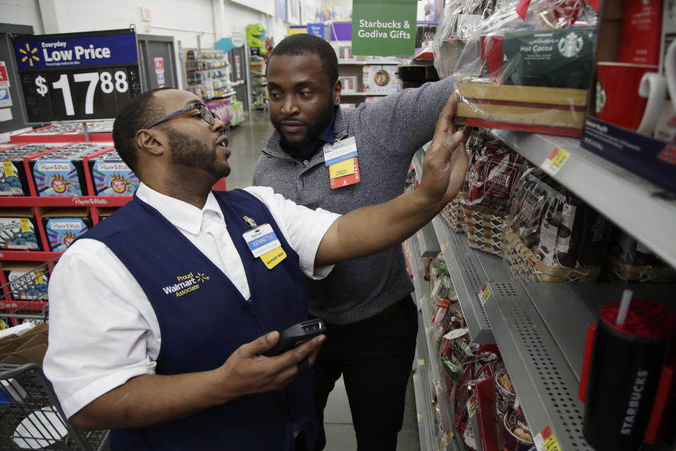 In this Thursday, Nov. 9, 2017, photo, Walmart employee Kenneth White, left, is coached by Shabazz Bonner while using an inventory app during a class at the Walmart Academy at the store in North Bergen, N.J. The retail industry is being radically reshaped by technology and nobody feels that disruption more starkly than the 16 million Americans working as shelf stockers, salespeople and cashiers. (AP Photo/Julio Cortez)