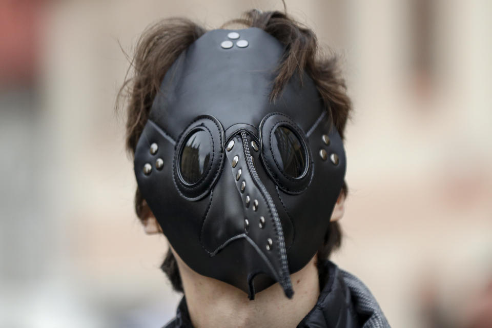 A man wears a mask as demonstrators gather to protest the COVID-19 preventative measures downtown Prague, Czech Republic, Wednesday, Oct. 28, 2020. Coronavirus infections in the Czech Republic have again jumped to record levels amid new restrictive measures imposed by the government to curb the spread. (AP Photo/Petr David Josek)