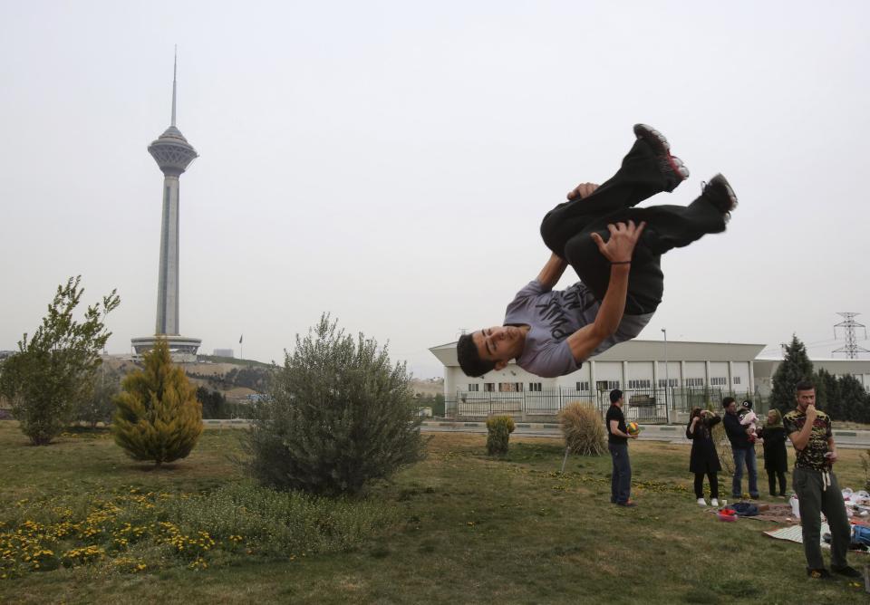 Iranian Omid Khosravi practices parkour during the ancient festival of Sizdeh Bedar, an annual public picnic day on the 13th day of the Iranian new year, in Tehran, Iran, Wednesday, April 2, 2014. Sizdeh Bedar, which comes from the Farsi words for “thirteen” and “day out,” is a legacy from Iran’s pre-Islamic past that hard-liners in the Islamic Republic never managed to erase from calendars. Many say it’s bad luck to stay indoors for the holiday. (AP Photo/Vahid Salemi)