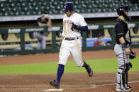 Houston Astros center fielder George Springer, left, scores behind Arizona Diamondbacks catcher Daulton Varsho, right, on the line-drive double by Jose Altuve during the sixth inning of a baseball game Saturday, Sept. 19, 2020, in Houston. (AP Photo/Michael Wyke)