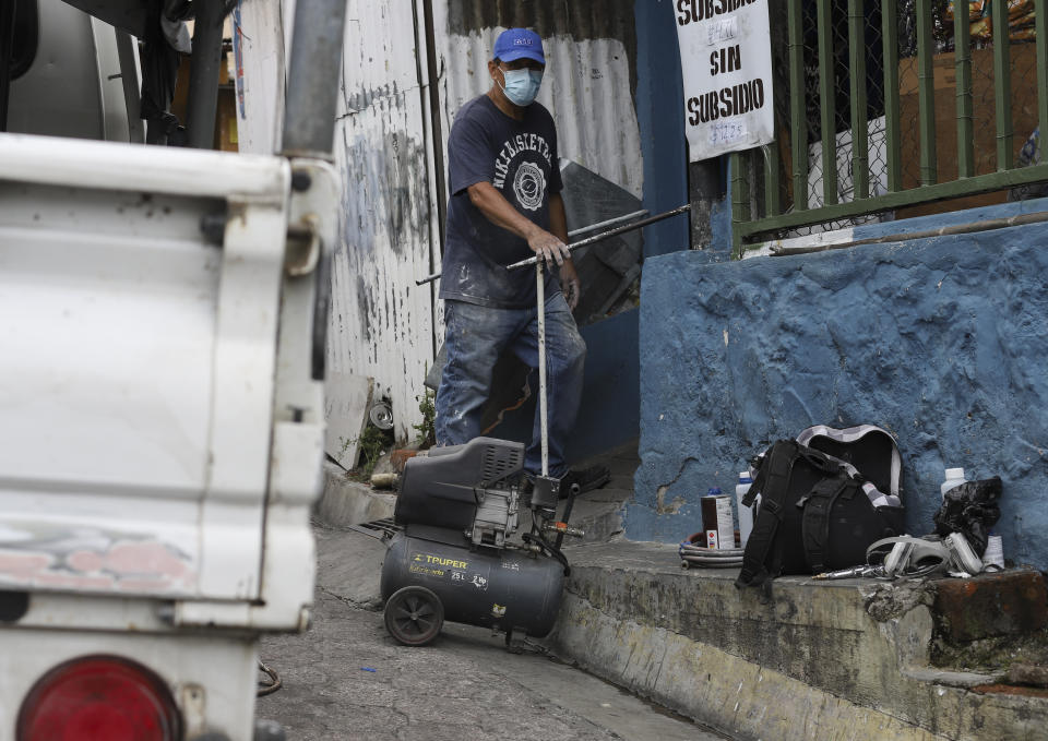 Julio Cesar Lopez, a painter, prepares his tools of his trade in the Las Palmas neighborhood, in San Salvador, El Salvador, Thursday, June 3, 2021. "They talk about democracy... I don't know what else," said the 60-year-old. "It makes me really happy that they're kicking out that class of people", referring to the government of Nayib Bukele who enjoys an approval rating of more than 90% among people who saw three of four previous presidents jailed or exiled for corruption. (AP Photo/Salvador Melendez)