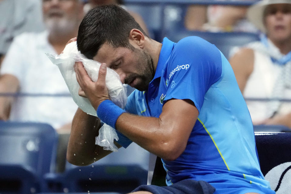 FILE - Novak Djokovic, of Serbia, cools off during a break as he plays Borna Gojo, of Croatia, during the fourth round of the U.S. Open tennis championships, Sept. 3, 2023, in New York. An Associated Press analysis shows the average high temperatures during the U.S. Open and the three other Grand Slam tennis tournaments steadily have grown hotter and more dangerous in recent decades. (AP Photo/John Minchillo, File)