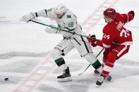 Dallas Stars center Jason Dickinson (18) attempts to reach a loose puck ahead of Detroit Red Wings right wing Richard Panik (24) in the first period of an NHL hockey game in Dallas, Tuesday, April 20, 2021. (AP Photo/Tony Gutierrez)