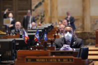 FILE - In this March 31, 2020 file photo, State Rep. Vincent Pierre, D-Dist. 44, wears a mask and gloves as legislators convene in a limited number while exercising social distancing, due to the new coronavirus pandemic, at the state Capitol in Baton Rouge, La. Where political divides marred early recovery efforts after Hurricane Katrina in 2005, Louisiana is showing rare political unity in the fight against the new coronavirus. (AP Photo/Gerald Herbert, File)