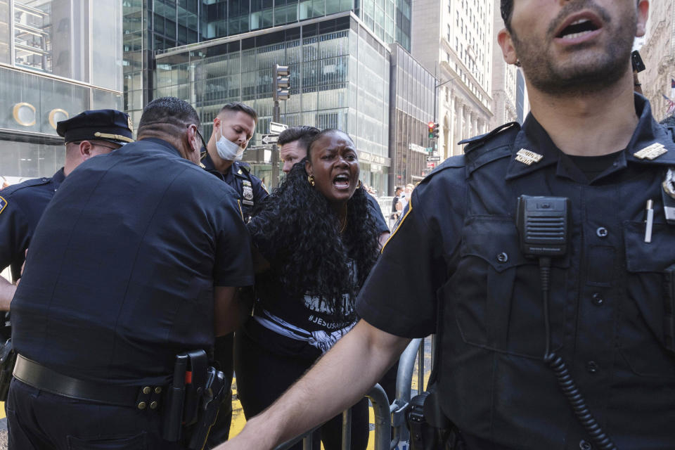 NYPD officers detain a protester who poured black paint on the Black Lives Matter mural outside of Trump Tower on Fifth Avenue in the Manhattan borough of New York on Saturday, July 18, 2020. (AP Photo/Yuki Iwamura)