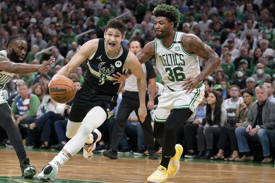 Milwaukee Bucks guard Grayson Allen, center, drives toward the basket as Boston Celtics guard Marcus Smart, right, defends during the first half of Game 7 of an NBA basketball Eastern Conference semifinals playoff series, Sunday, May 15, 2022, in Boston. (AP Photo/Steven Senne)