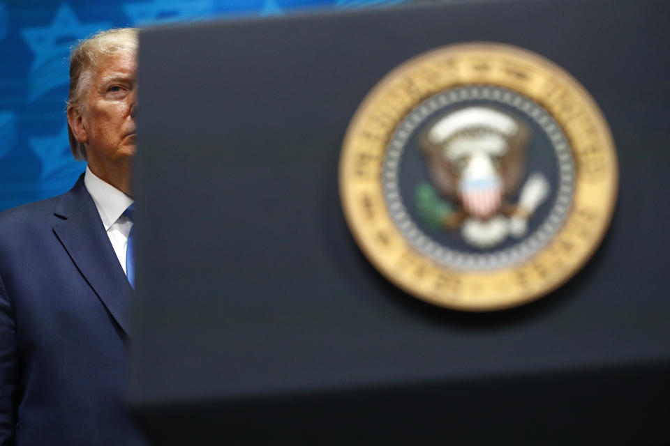 President Donald Trump listens as Miriam Adelson, the wife of Las Vegas Sands Corporation Chief Executive and Republican mega donor Sheldon Adelson, introduces him at the Israeli American Council National Summit in Hollywood, Fla., Saturday, Dec. 7, 2019. (AP Photo/Patrick Semansky)