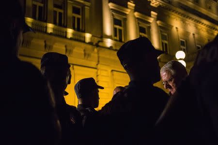 Serbian nationalist leader Vojislav Seselj (R) is stopped by riot police during a commemoration for the victims of the 1995 Srebrenica massacre, in downtown Belgrade, Serbia July 10, 2015. REUTERS/Marko Djurica