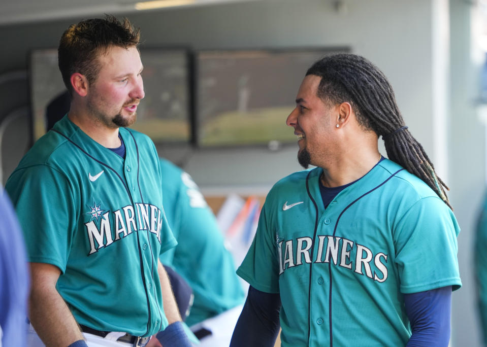 Seattle Mariners' Cal Raleigh, left, talks with starting pitcher Luis Castillo, right, after Castillo pitched through six innings against the Pittsburgh Pirates in a baseball game Saturday, May 27, 2023, in Seattle. (AP Photo/Lindsey Wasson)