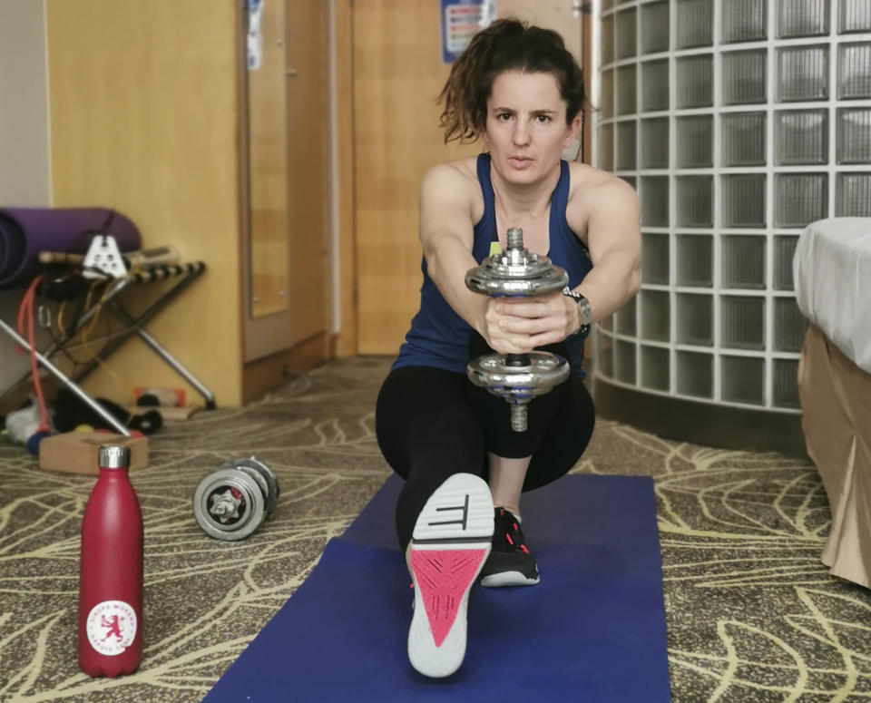 Swiss snowboarder Patrizia Kummer works out in her hotel room in Beijing on Jan. 19, 2022 where is undergoing a 21 day quarantine. Three weeks alone in a hotel room is hardly an ideal setting for a snowboarder preparing for the Olympics. Kummer, a Swiss competitor who won a gold medal at the 2014 Sochi Olympics, is unvaccinated against the coronavirus by choice, so she is spending 21 days in isolation in China before the Winter Games begin in Beijing on Feb. 4. (Patrizia Kummer via AP)