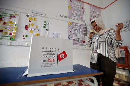 Electoral worker prepares a ballot box inside a polling station during presidential election in Tunis