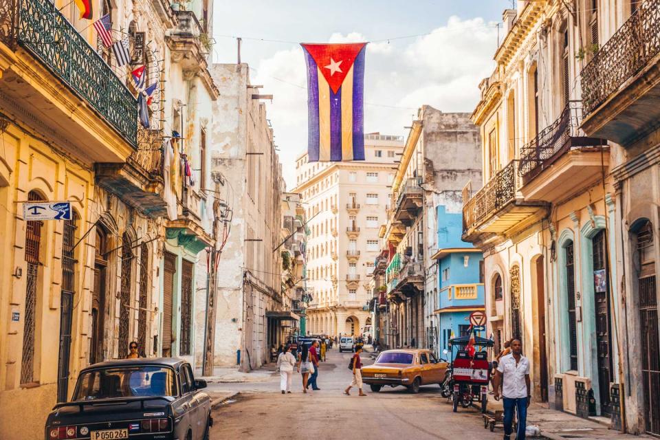 A Cuban flag hanging over a street in Havana, Cuba