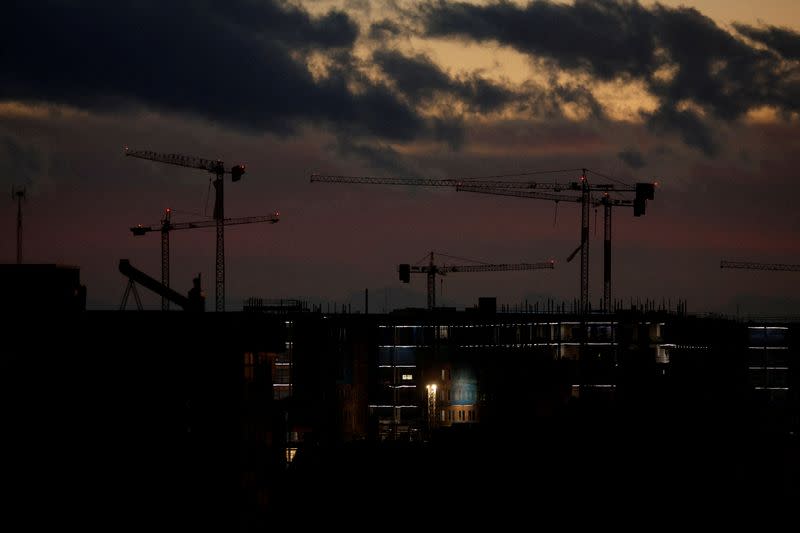 FILE PHOTO: Construction cranes are seen at dusk in Madrid