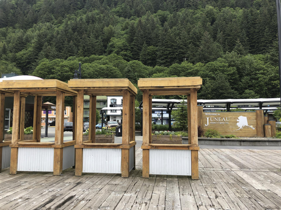 Stalls that during typical summers are filled with workers offering shore-side excursions to cruise ship passengers stand empty Monday, June 15, 2020, in Juneau, Alaska. Tourism is one of the main drivers of the Alaska economy, which means some businesses are suffering during the pandemic. (AP Photo/Becky Bohrer)