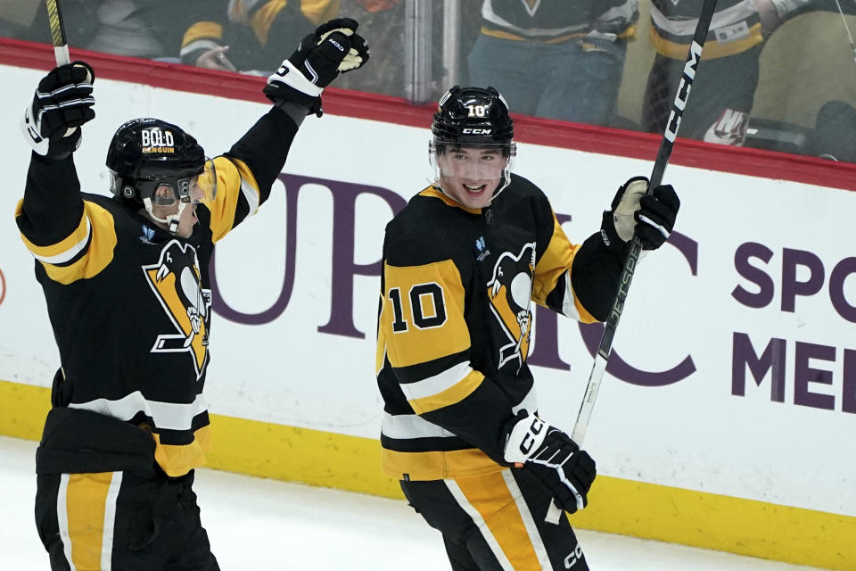 Pittsburgh Penguins' Drew O'Connor (10) celebrates with Evgeni Malkin (71), left, after scoring against the St. Louis Blues during the first period of an NHL hockey game Saturday, Dec. 30, 2023, in Pittsburgh. (AP Photo/Matt Freed)