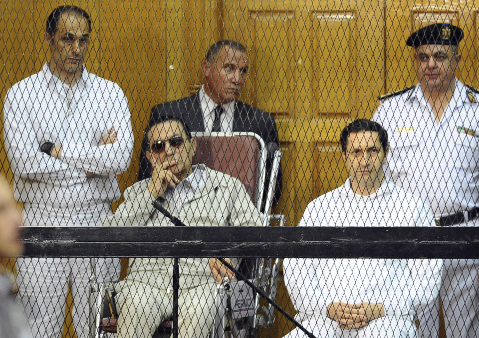 FILE -Former Egyptian President Hosni Mubarak, seated center left, and his two sons, Gamal Mubarak, left, and Alaa Mubarak attend a hearing in a courtroom in Cairo, Egypt on Sept. 14, 2013. Gamal Mubarak said Tuesday, May 17, 2022, that he and family members were innocent of corruption charges made in international courts after the country’s 2011 popular uprising. His statements came after years of attempts by the deposed president's family to rehabilitate its image as it faced litigation in Egypt and abroad. (AP Photo/Mohammed al-Law, File)