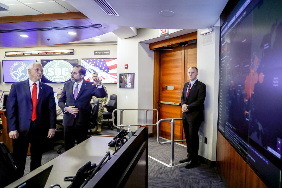 Vice President Mike Pence, left, and Health and Human Services Secretary Alex Azar, second from left, look at a large monitor displaying a tally of total coronavirus cases, deaths, and recovered, as they tour the Secretary's Operations Center following a coronavirus task force meeting at the Department of Health and Human Services, Thursday, Feb. 27, 2020, in Washington. (AP Photo/Andrew Harnik)