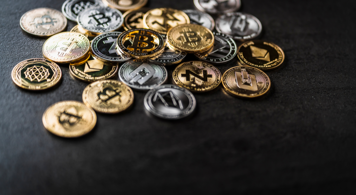 A photo of various crypto coins on a black surface.