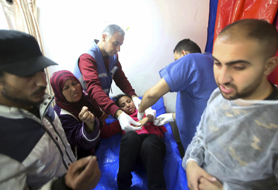 Palestinian medics treat a girl wounded in the Israeli bombardment at a building of an UNRWA vocational training center which displaced people use as a shelter in Khan Younis, southern Gaza Strip, Wednesday, Jan. 24, 2024. (AP Photo/Ramez Habboub)