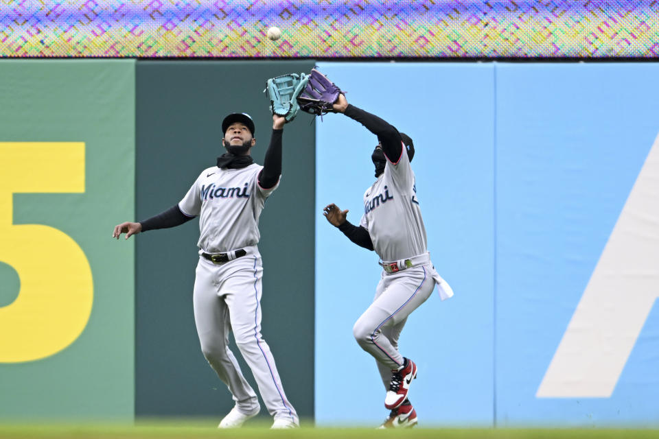 Miami Marlins' Bryan De La Cruz, left, and Jazz Chisholm Jr. compete for a fly ball hit by Cleveland Guardians José Ramírez during the fifth inning of a baseball game, Sunday, April 23, 2023, in Cleveland. Ramírez was out on the play. (AP Photo/Nick Cammett)