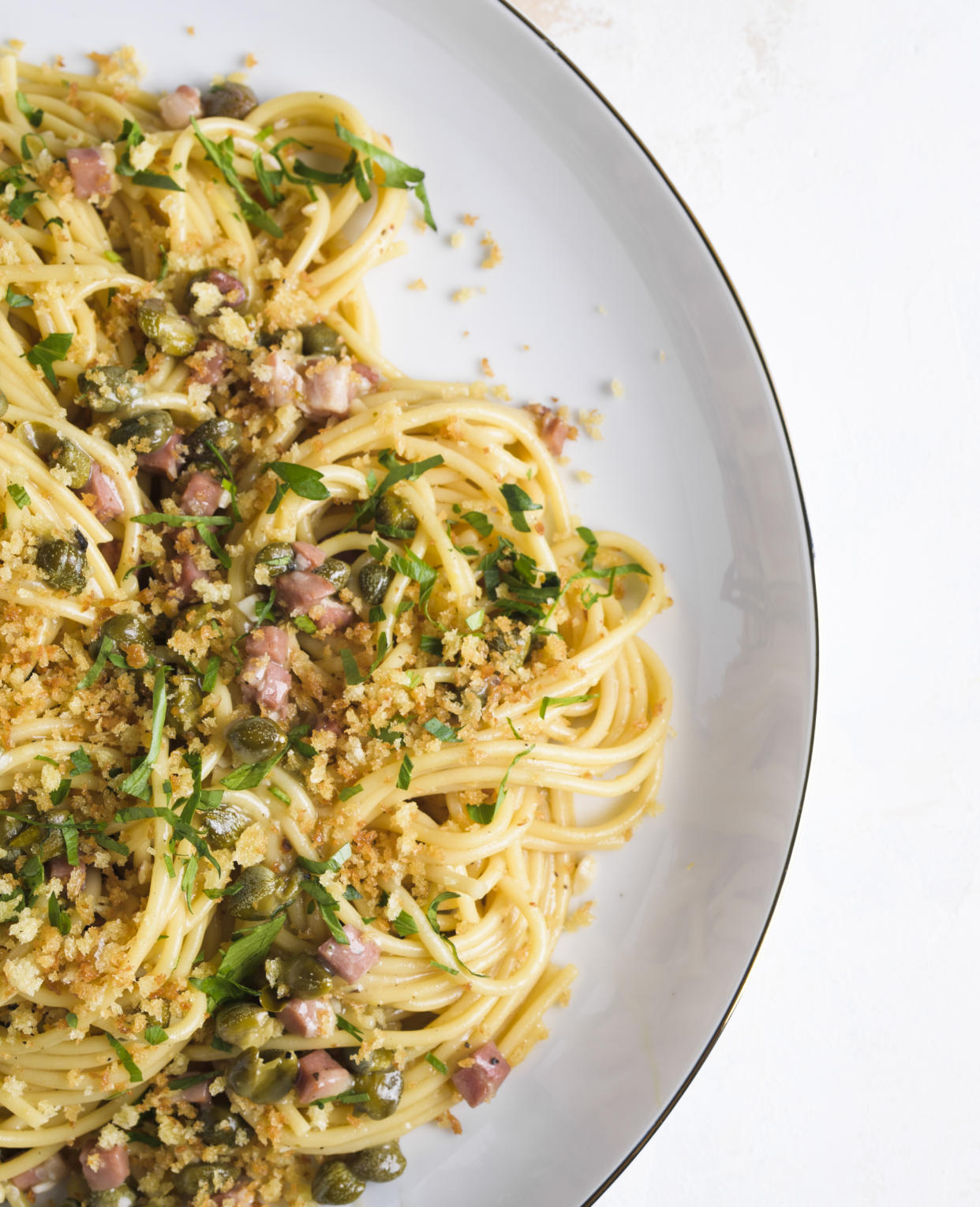 This image released by Milk Street shows a recipe for Lemon Caper Spaghetti with Pancetta and Toasted Breadcrumbs. (Milk Street via AP)