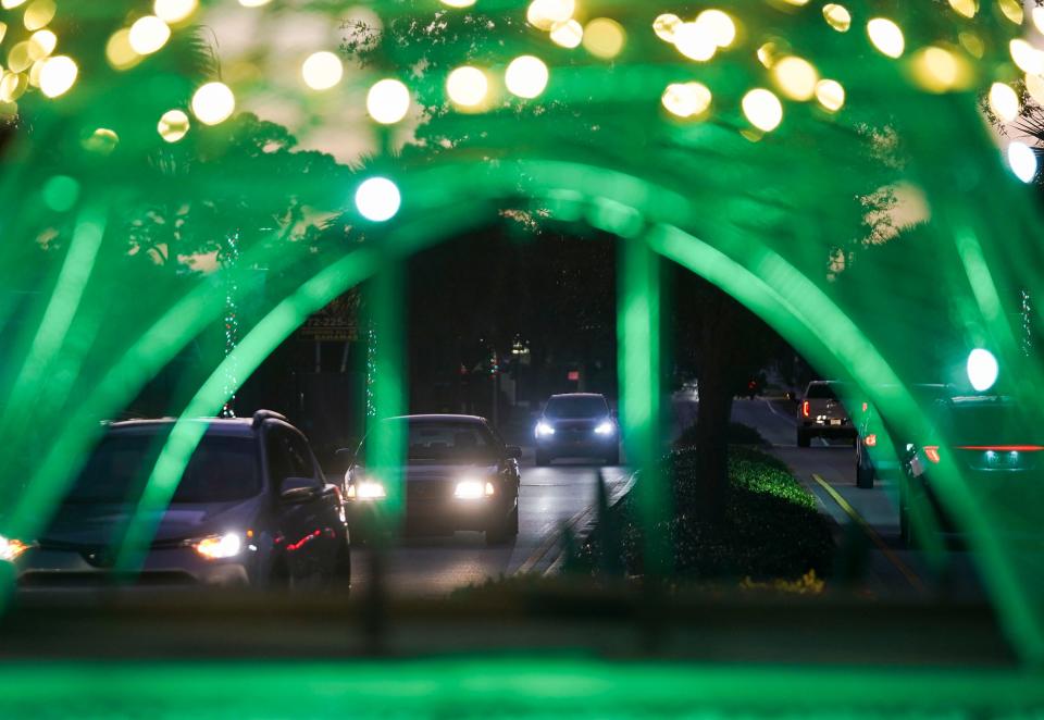 Traffic is seen through the 12.5-foot replica of the Eiffel Tower at the roundabout at Dixie Highway and Martin Avenue on Thursday, Dec. 8, 2022, in Rio. Jim and Susanne LoPilato built the replica that is displayed near their home. "He doesn't want to go to Paris so he brought Paris to me," said Susanne. The family also decorated 25 street lights heading in all directions from the roundabout, making them look like giant candy canes.