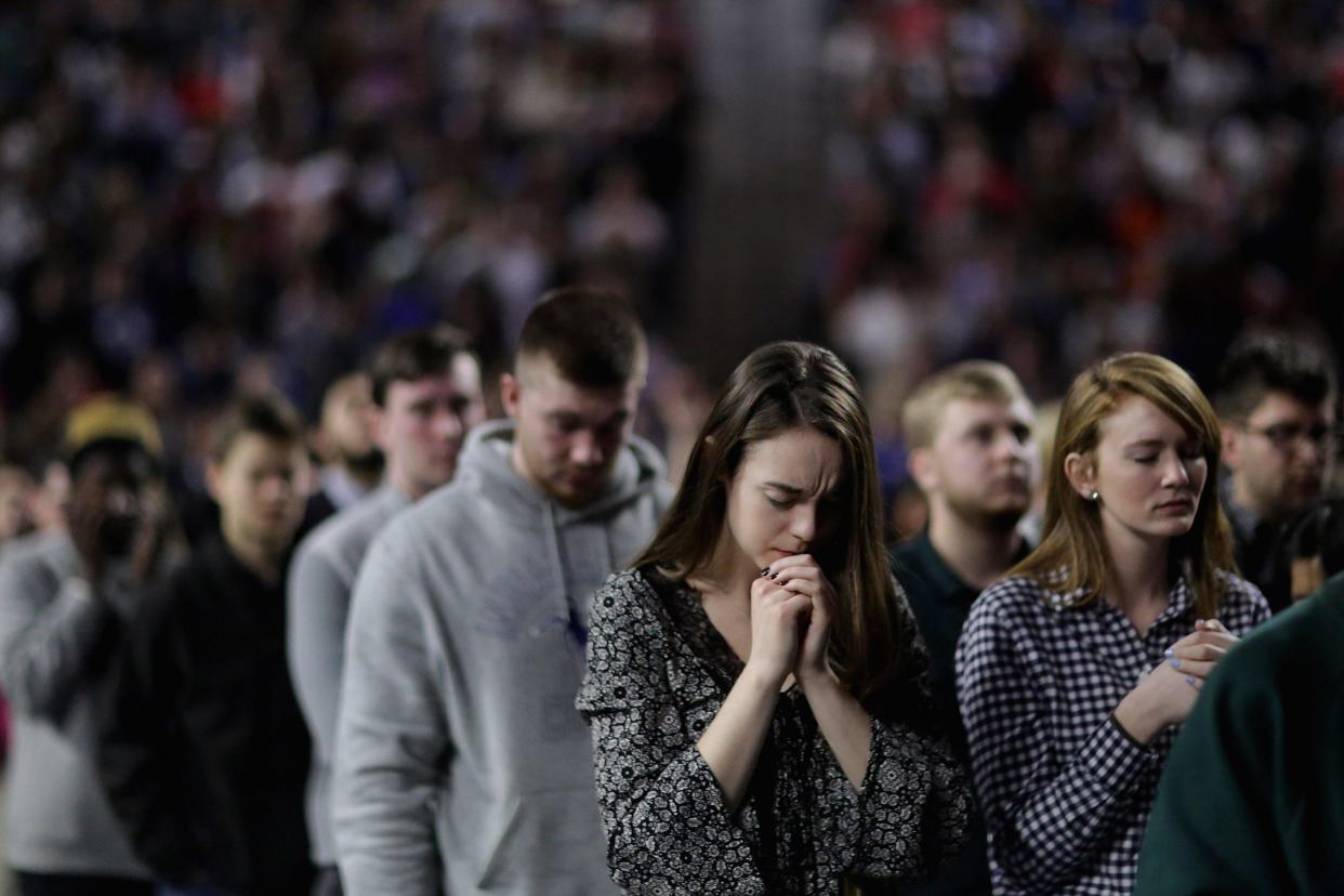 Thousands of students, supporters and invited guests bowed their heads in prayer before Republican presidential candidate Donald Trump delivers the convocation on the campus of Liberty University in 2016.