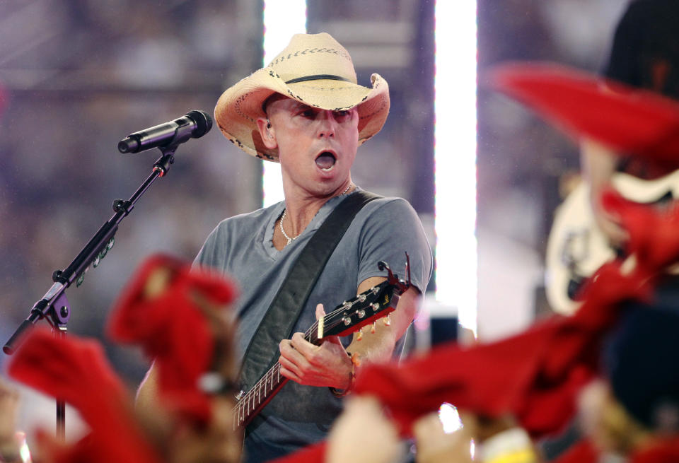 FILE - In this Nov. 22, 2012, file photo, country singer Kenny Chesney performs during halt time of an NFL football game between the Dallas Cowboys and Washington Redskins in Arlington, Texas. For country music's biggest star — Chesney is the only country act in Billboard's Top 10 touring artists of the last quarter-century — and a nominee for a ninth Entertainer of the Year honor at next week's CMA awards show, the marriage of music and sports is a natural. (AP Photo/Tim Sharp, file)