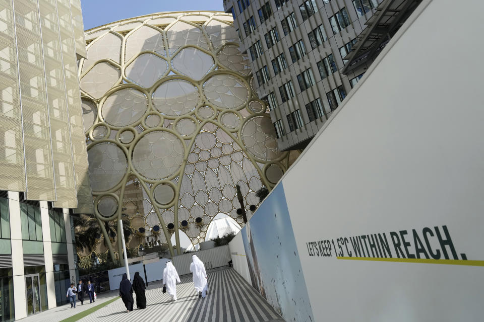 People walk near the Al Wasl Dome at Expo City ahead of the COP28 U.N. Climate Summit, Tuesday, Nov. 28, 2023, in Dubai, United Arab Emirates. (AP Photo/Peter Dejong)