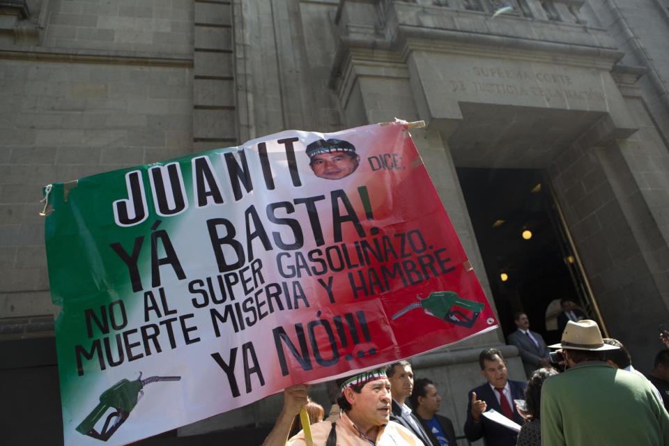 Juanito, a well-known longtime political activist, holds a sign that says in Spanish "Juanito says enough already! No to the super gasoline price hike. Death, misery, and hunger. No more!" as he protests at the Supreme Court in Mexico City, Monday, Jan. 2, 2017. Protesters are blockading some roads and fuel stations in Mexico to protest a price deregulation that sent fuel prices up by as much as 20 percent. (AP Photo/Rebecca Blackwell)