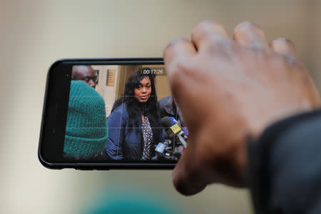 A man uses his phone to take video of Tamara Lanier speak to the media about a lawsuit accusing Harvard University of the monetization of photographic images of her great-great-great grandfather, an enslaved African man named Renty, and his daughter, Delia outside of the Harvard Club in New York, U.S., March 20, 2019. REUTERS/Lucas Jackson
