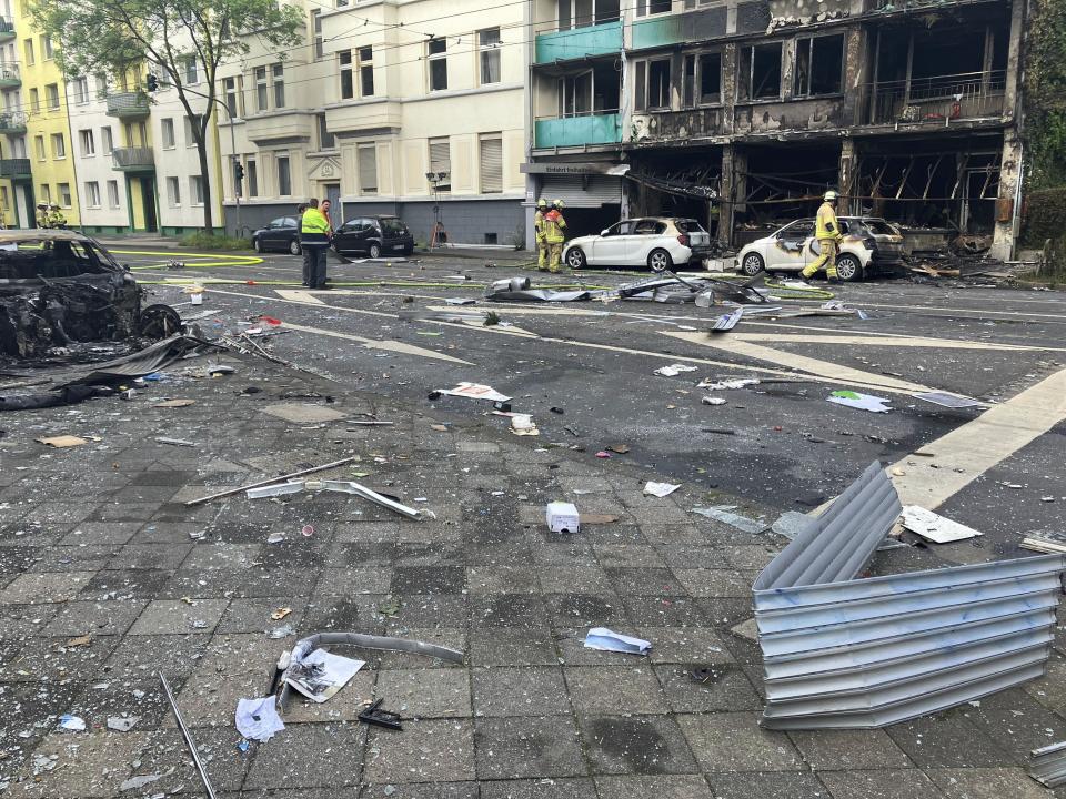 Debris lies on a street in front of a house in which a fire raged, in Duesseldorf, Germany, Thursday May 16, 2024. Several people died and others were injured in the fire in Duesseldorf. According to the fire department, a kiosk integrated into a residential building caught fire on Thursday night for reasons as yet unexplained. (Jana Glose/dpa via AP)