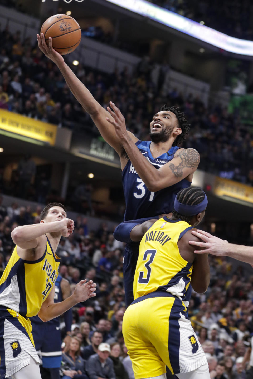 Minnesota Timberwolves forward Keita Bates-Diop (31) shoots over Indiana Pacers guard Aaron Holiday (3) during the first half of an NBA basketball game in Indianapolis, Friday, Jan. 17, 2020. (AP Photo/Michael Conroy)