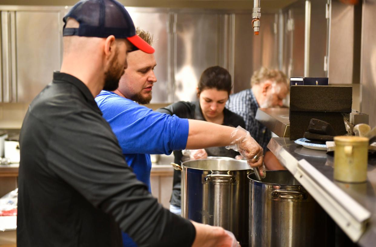 Volunteers work to prepare large pots of food for easter meals as part of the non-profit Faith Feeds MN Thursday, April 14, 2022, in the kitchen area of Heritage Hall at the Church of St. Joseph. 