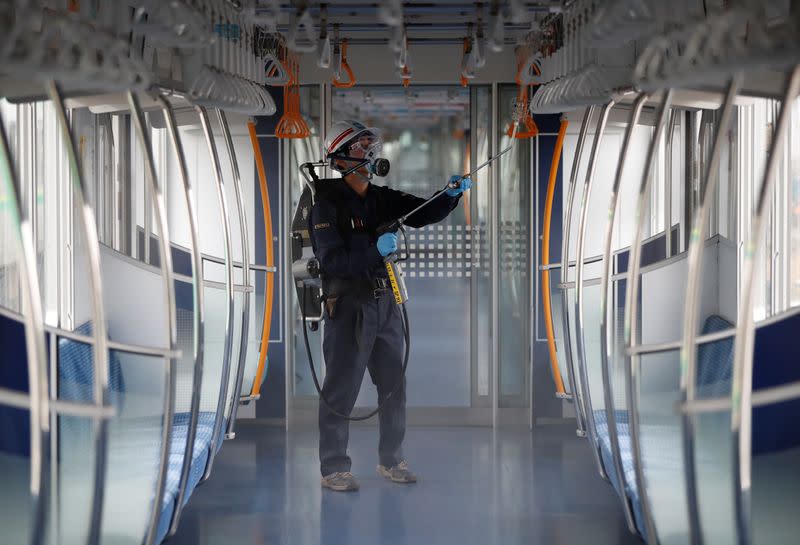 An employee of the Tokyo Metro sprays chemicals for anti-virus and bacteria coating in order to prevent infections following the coronavirus disease (COVID-19) outbreak in Tokyo