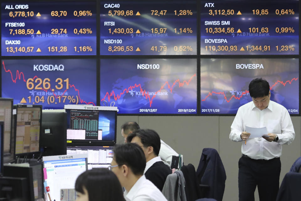 A currency trader reads documents at the foreign exchange dealing room of the KEB Hana Bank headquarters in Seoul, South Korea, Thursday, Dec. 5, 2019. Asian shares were rising Thursday amid renewed hopes a U.S. trade deal with China may be nearing, despite tough recent talk from President Donald Trump.(AP Photo/Ahn Young-joon)