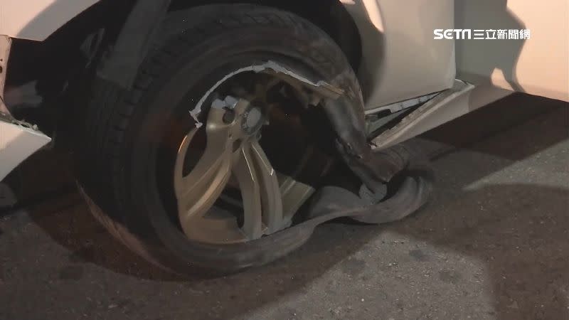 白色名車自撞安全島，保險桿和輪胎嚴重毀損。