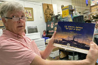 Fred Holabird, president of Holabird Western Americana Collections, poses with a catalog of Gold Rush-era collectibles recovered from the 1857 shipwreck of the S.S. Central America in a storage room at his office in Reno, Nev., on Friday, Nov. 25, 2022. Items from the shipwreck will be offered for public sale at the first of two public auctions on Dec. 3 in Reno. (AP Photo/Scott Sonner)