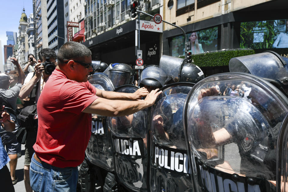 FILE - Anti-government protesters confront police to protest the economic reforms of Argentine President Javier Milei outside the Supreme Court as labor unions legally challenge the measures in Buenos Aires, Argentina, Dec. 27, 2023. Milei has drastically cut spending to end the fiscal deficit and contain inflation of almost 161% annually, including devaluing the peso more than 50%, dismissing public employees, suspending public works and reducing transportation and energy subsidies. (AP Photo/Gustavo Garello, File)